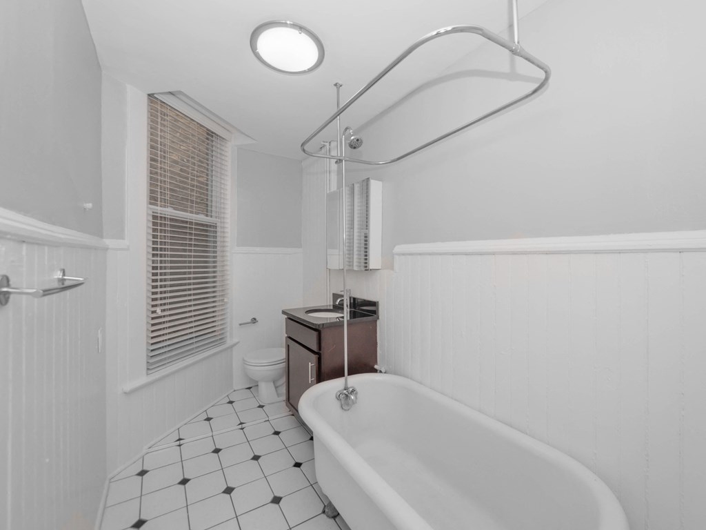 a white bathroom with a claw foot tub and a toilet