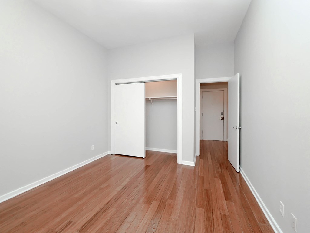 an empty living room with wood floors and white walls