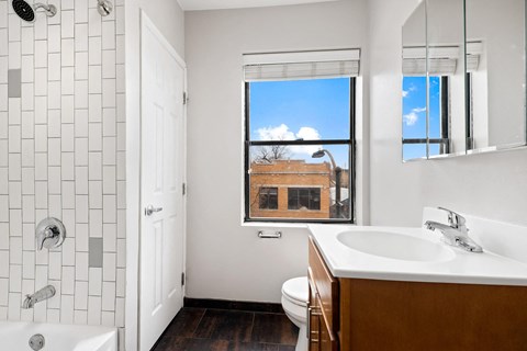 a bathroom with a sink toilet and a window