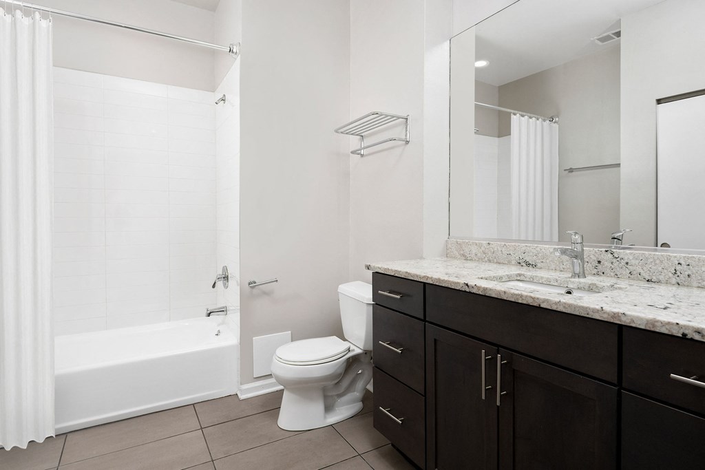 a bathroom with a toilet and a shower and a sink