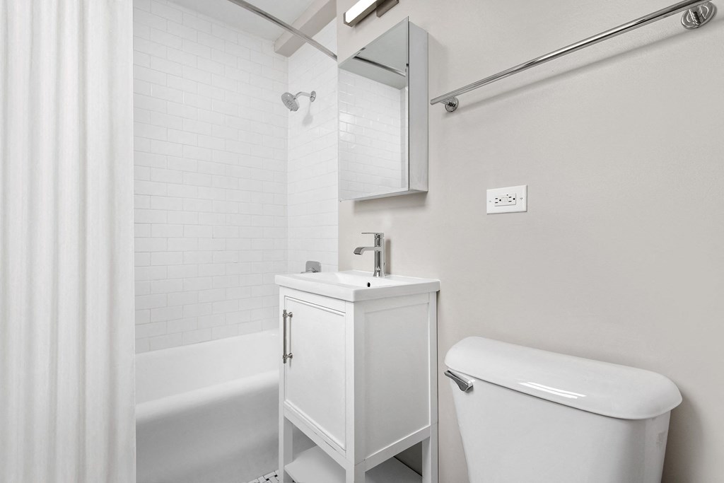 a bathroom with a sink and a toilet and a bath tub