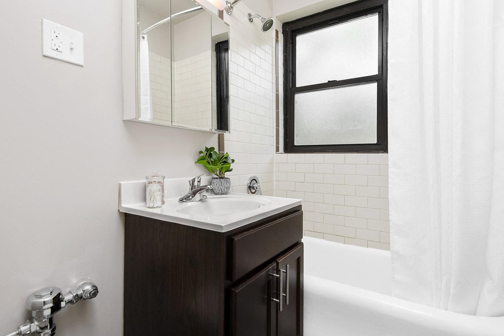 a bathroom with a sink and a window and a tub