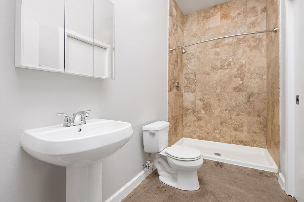 a bathroom with a sink and a toilet and a shower