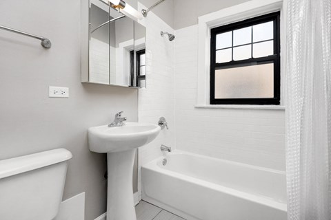 a bathroom with a sink and a tub and a window