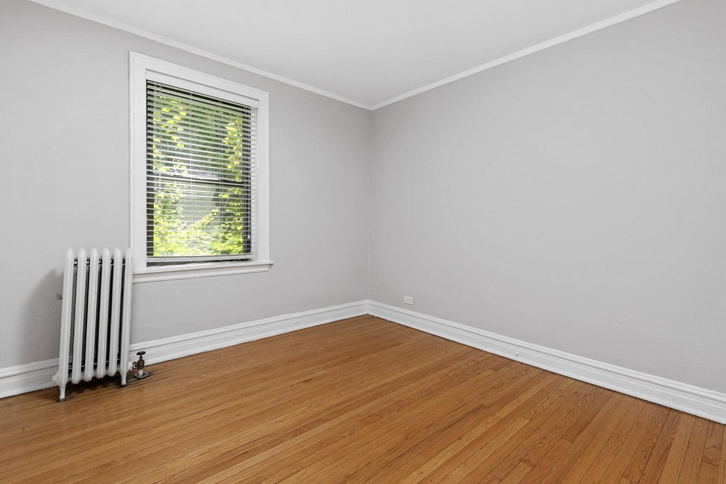 an empty room with a radiator and a window