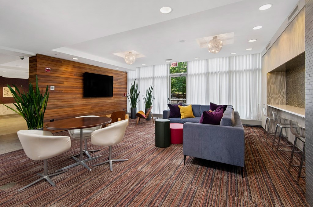 A modern living room with a wooden accent wall and a flat screen TV.