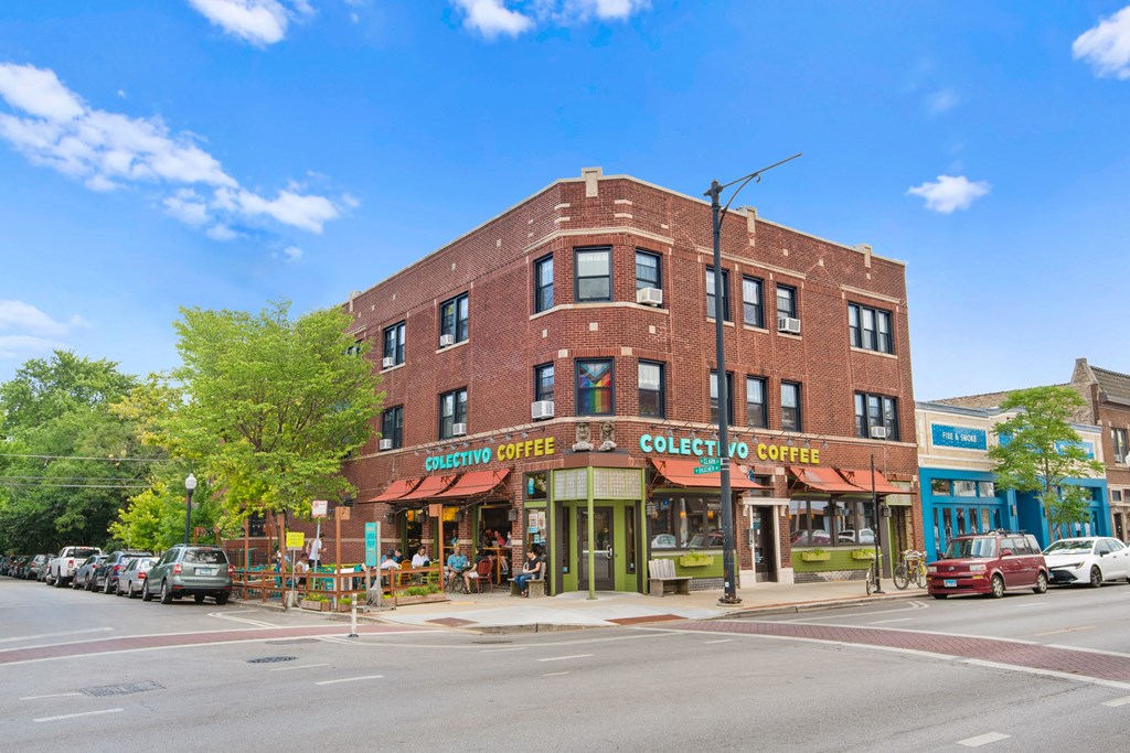 a brick building with a coffee shop on the corner of a street