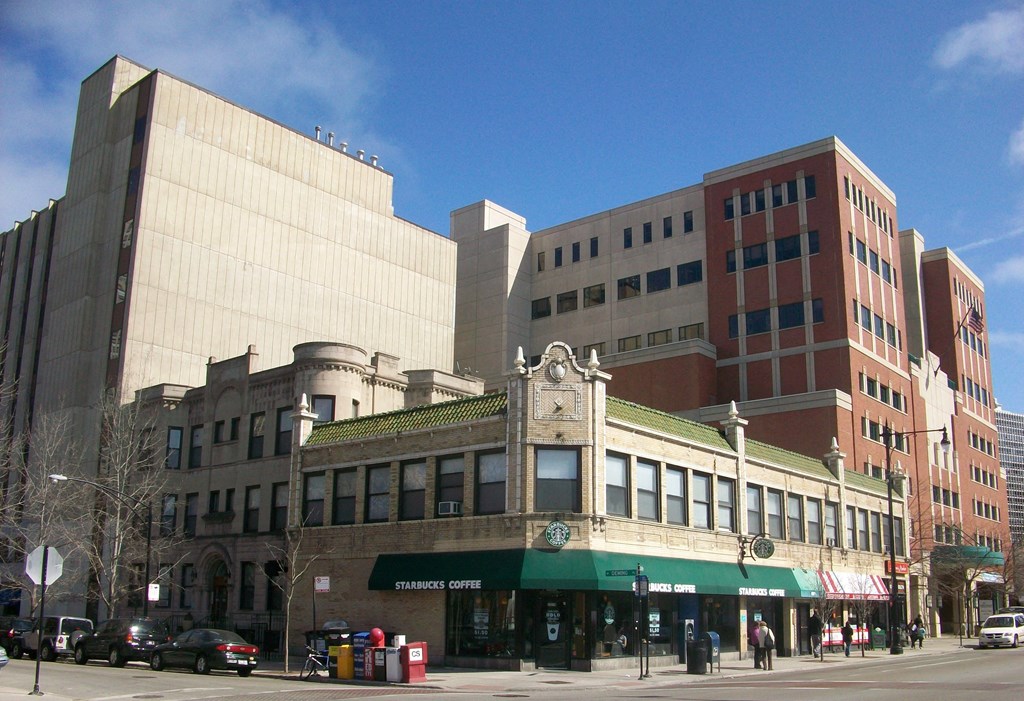 the corner of a city street with tall buildings