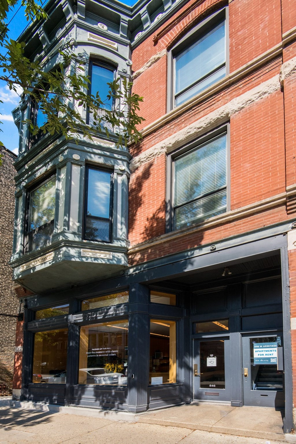 Community the front of a building with a black door and a red brick facade