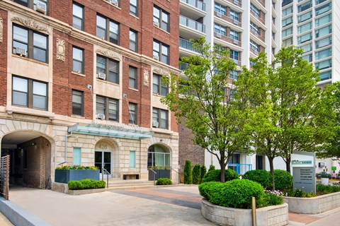 an apartment building with a courtyard and trees in front of it