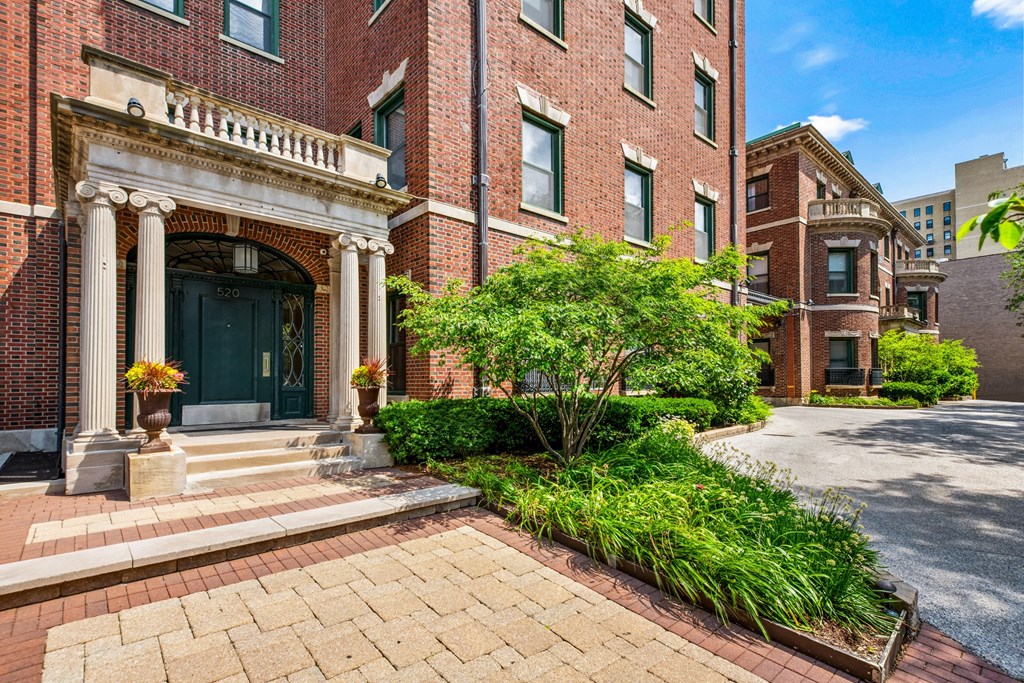 the front of a brick building with a green door