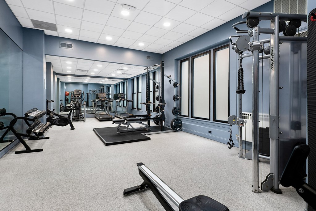 a spacious fitness room with cardio machines and weights