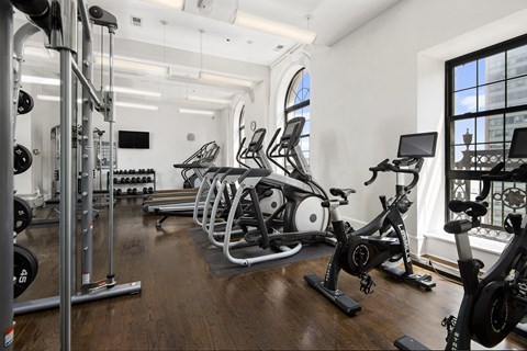 a row of exercise bikes in a room with a large window