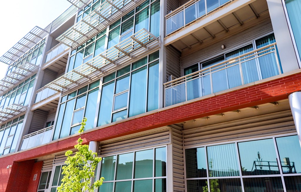 an apartment building with large windows and a balcony