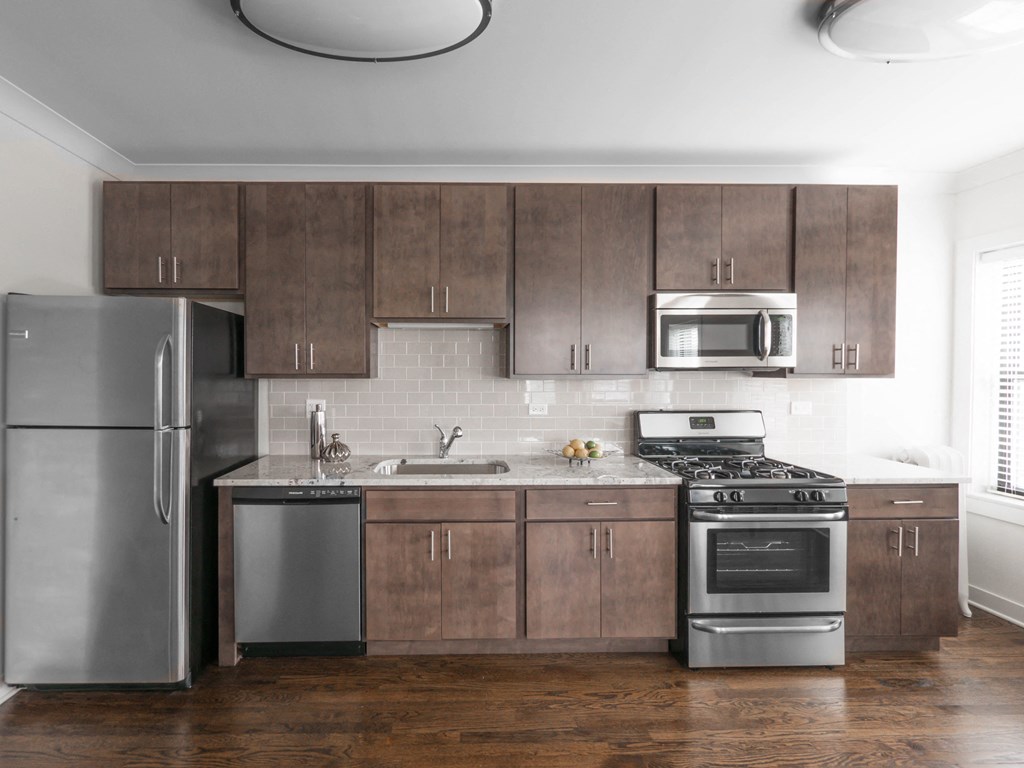 a kitchen with wooden cabinets and stainless steel appliances