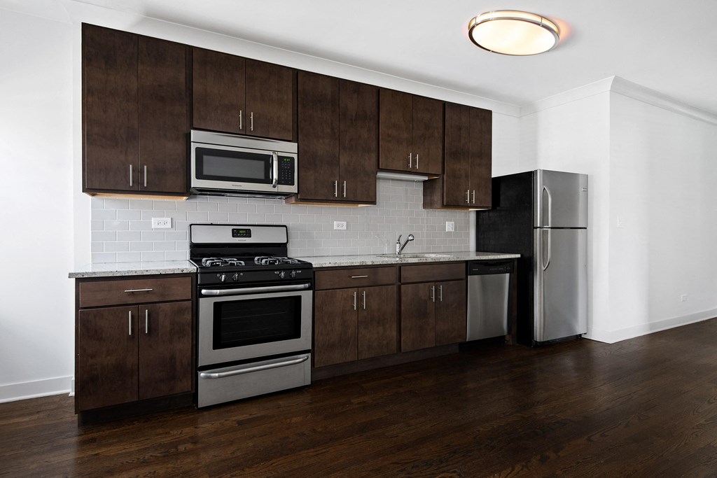 a kitchen with wooden cabinets and stainless steel appliances