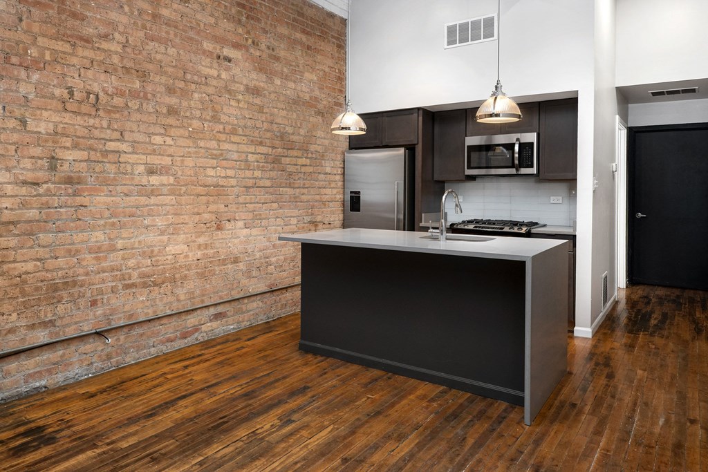 a kitchen with an island and a brick wall