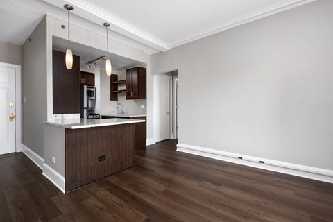 a renovated living room and kitchen with wood floors and white walls