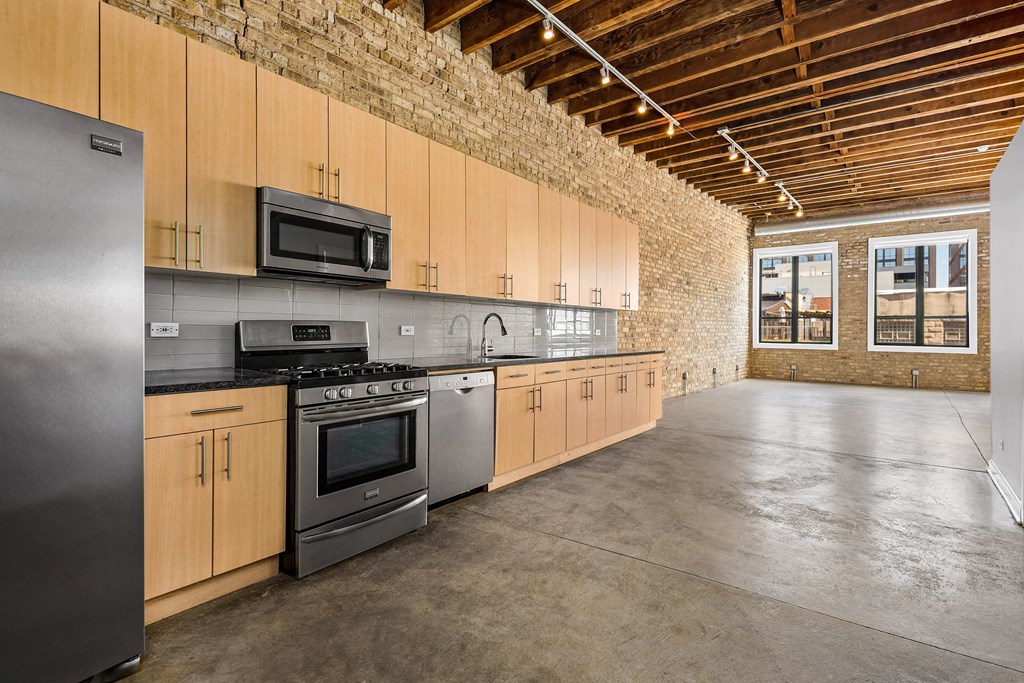 a large kitchen with wooden cabinets and stainless steel appliances