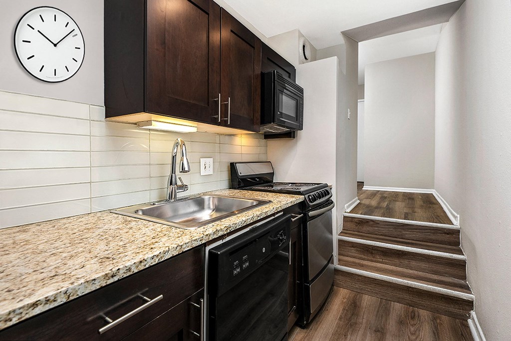 a kitchen with a sink and a clock on the wall