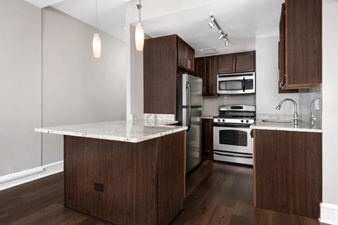 Apartment a kitchen with wooden cabinets and stainless steel appliances