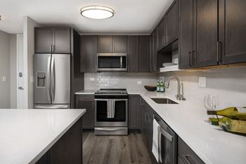 a kitchen with stainless steel appliances and white countertops