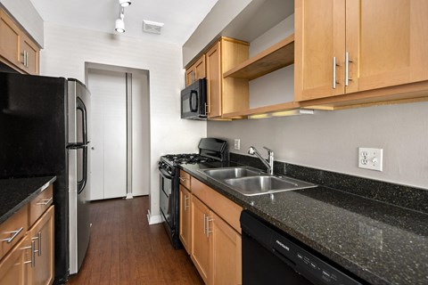 a kitchen with granite counter tops and black appliances