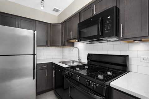a kitchen with black and white appliances and a stainless steel refrigerator
