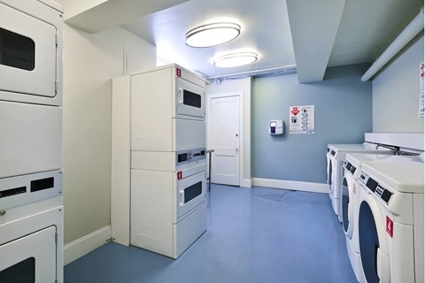 a laundry room with white appliances and blue flooring