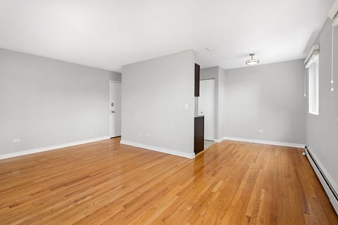 an empty living room with wood floors and grey walls