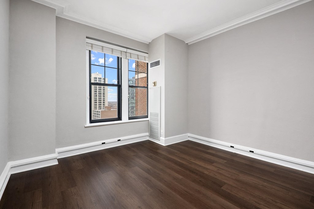 an empty living room with wood floors and a window