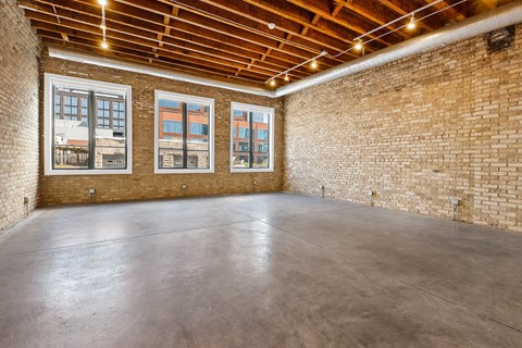 an empty room with brick walls and a concrete floor