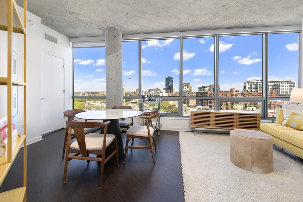 a living room with a view of a city and a table and chairs