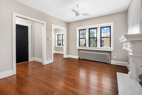 an empty living room with hardwood floors and a fireplace