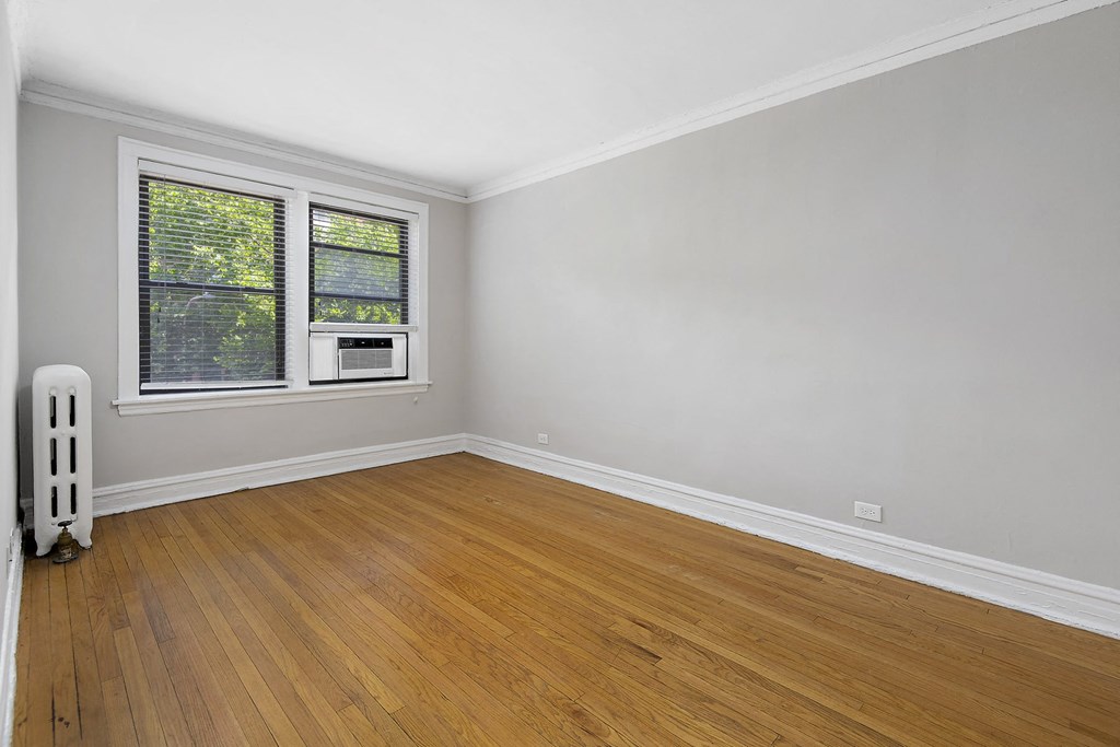 an empty room with wooden floors and a window