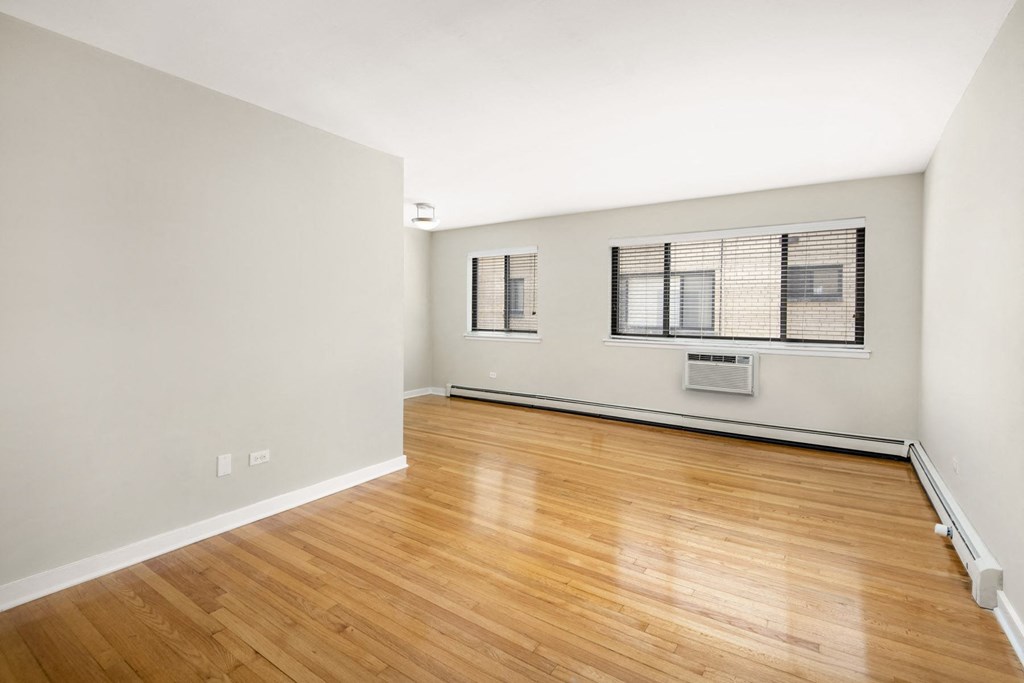 Apartment an empty living room with wood flooring and a window