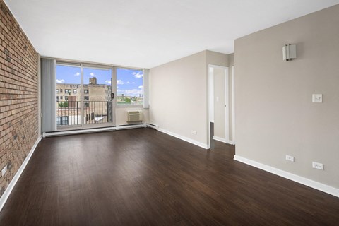 an empty living room with wood flooring and a window
