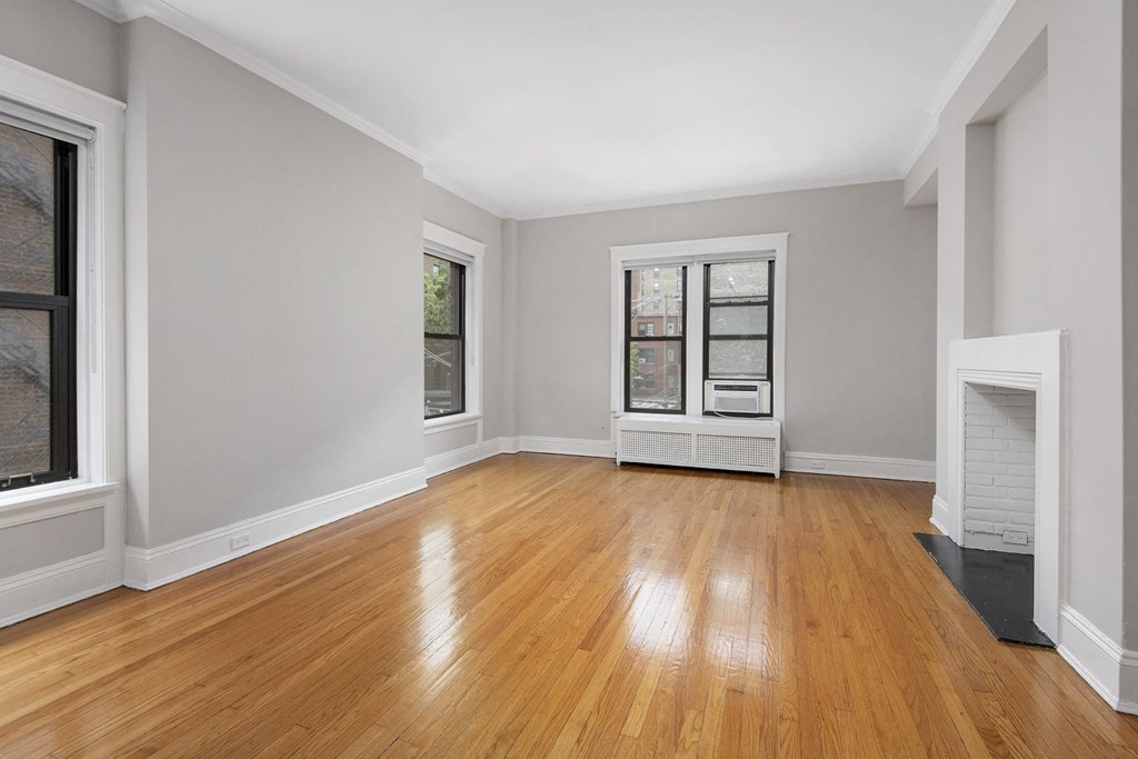 an empty living room with wood floors and a fireplace