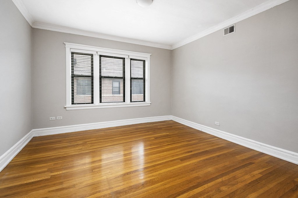 an empty living room with wood floors and a window