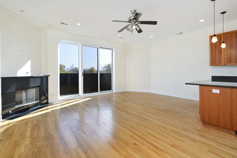 an empty living room with a fireplace and wood flooring