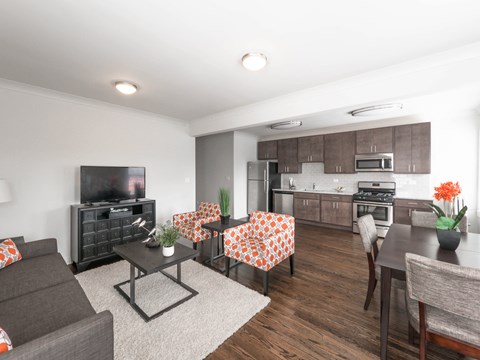 a living room and kitchen with a table and chairs