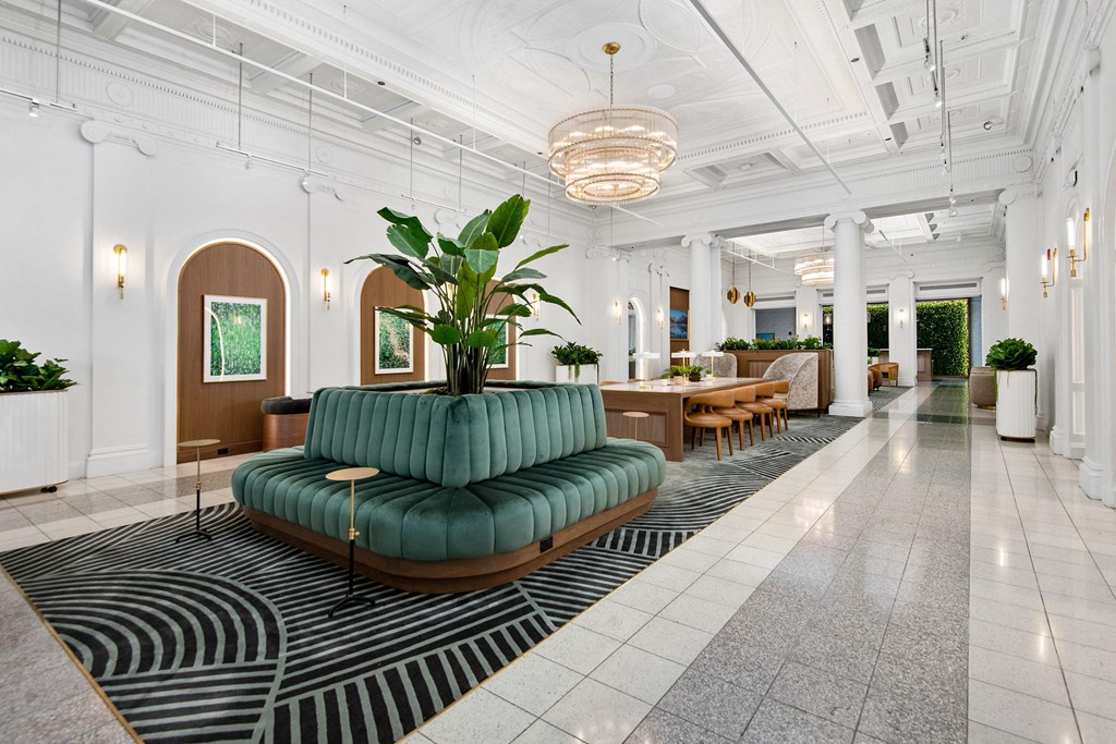 the lobby of a hotel with a green couch