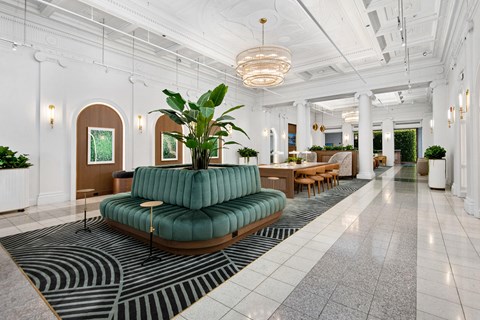 the lobby of a hotel with a green couch