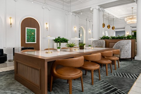 a long table in a room with chairs and lamps