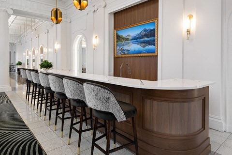 the bar in the lobby of a hotel with bar stools