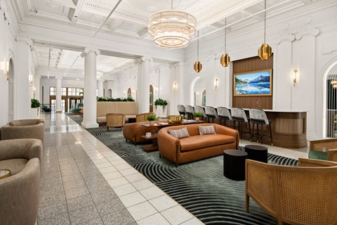 the lobby of a hotel with couches and chairs and a bar