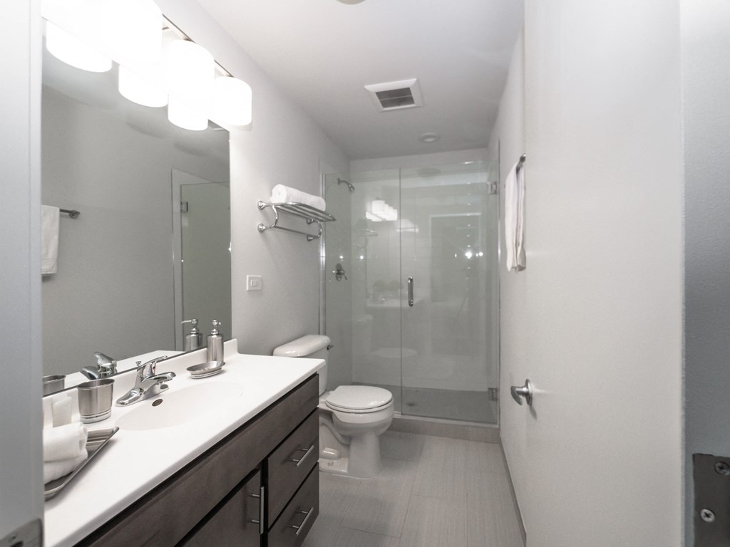 a bathroom with a shower and a sink and a toilet