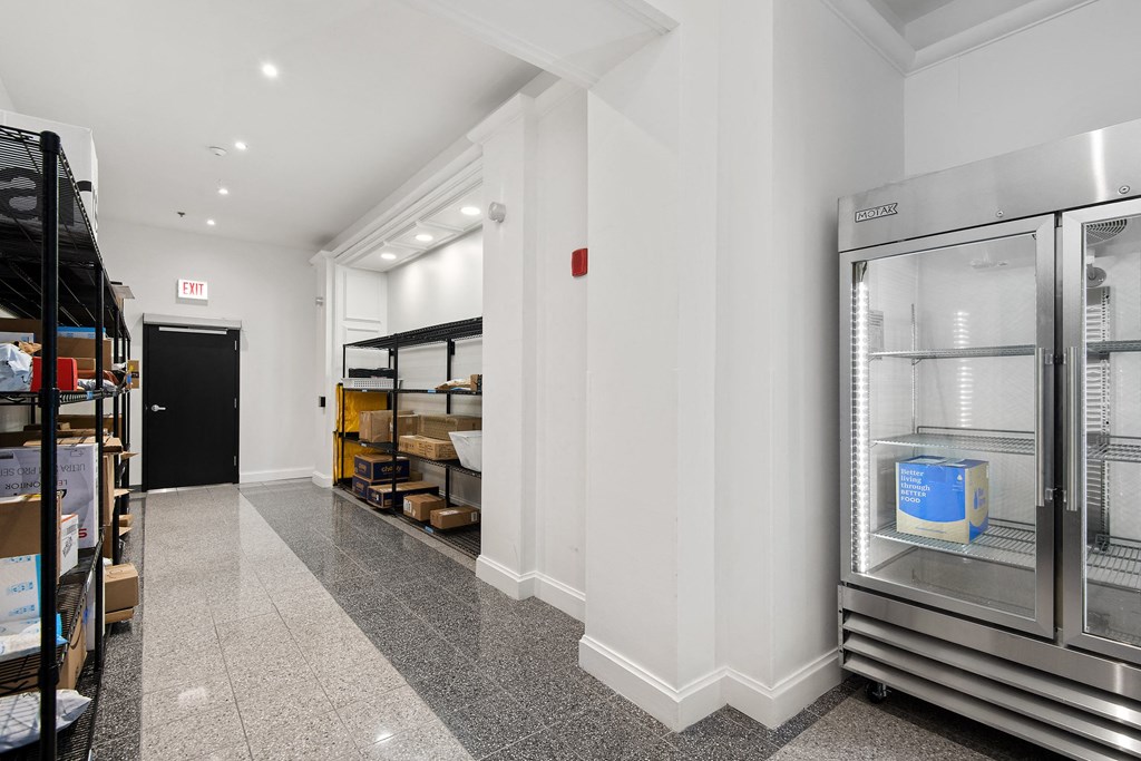 the interior of a store with white walls and glass refrigerators
