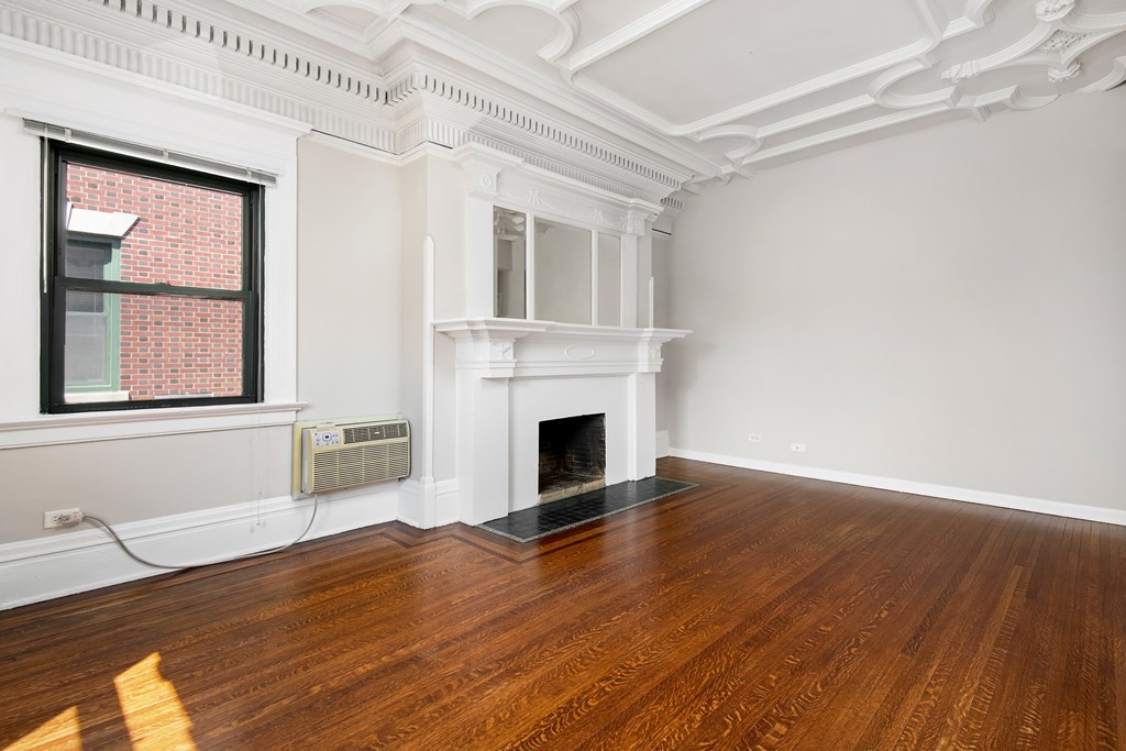 A room with a fireplace and a window.