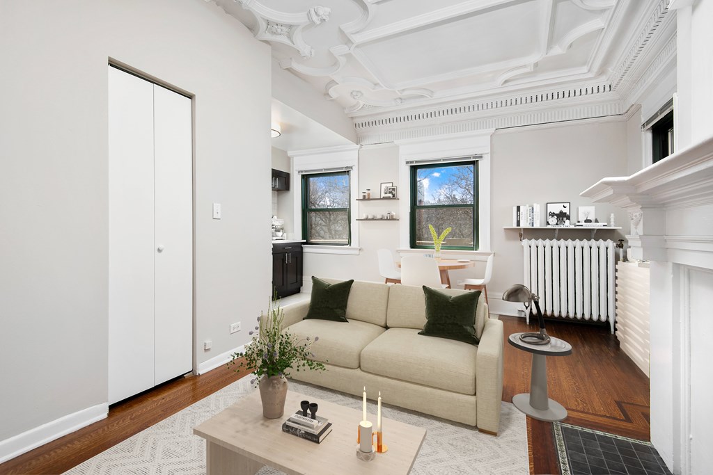 A living room with a beige couch, a coffee table, and a white ceiling.